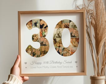 Op de afbeelding: Een ingelijst fotocollage in een licht houten lijst met een witte achtergrond. De cijfers 30 zijn gevormd uit een collage van foto's. De tekst "Happy 30th Birthday Sarah" en "Love from Matty, Claire and Tanya xxx" staat onder de cijfers.