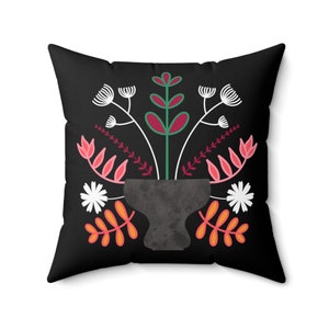 Könnte beinhalten: Schwarzes Kissen mit einem farbenfrohen Blumendesign. Das Design zeigt eine Vase mit rosa, roten und grünen Blumen auf schwarzem Hintergrund.