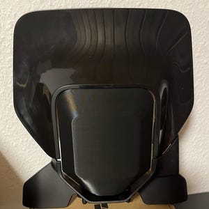 Könnte beinhalten: Schwarzer 3D-Drucker mit einem eleganten, modernen Design. Der Drucker verfügt über eine große Bauplattform und eine Touchscreen-Oberfläche. Der Drucker wird von Bambu Lab hergestellt.