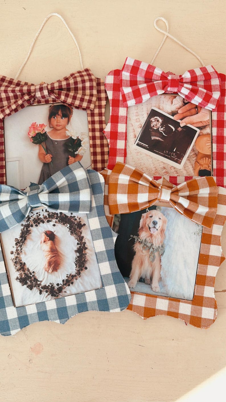 May include: Four decorative photo frames with gingham bows in red, blue, and orange. Each frame holds a different photo, including a child, a baby, a dog, and a sonogram. The frames are designed for wall hanging.