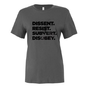 May include: A dark grey t-shirt with the text "DISSENT. RESIST. SUBVERT. DISOBEY." printed in black.