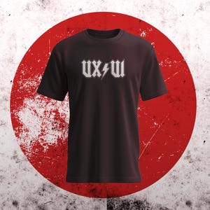 May include: Black t-shirt with the text "UX/UI" in a white, stylized font with a lightning bolt graphic. The shirt is displayed against a red and white background.
