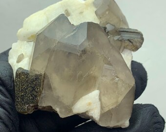 Ejemplar de cuarzo ahumado multiterminado con mica sobre feldespato / Exhibición de minerales de Pakistán