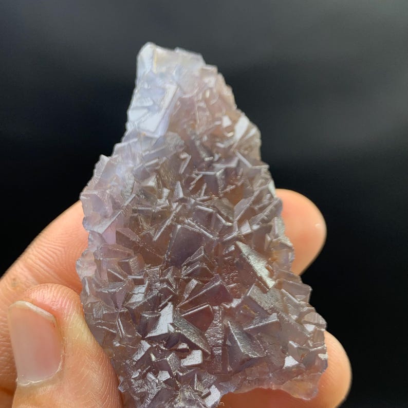 K&ouml;nnte beinhalten: Ein nat&uuml;rliches, rohes Fluorite-Kristall-Exemplar. Der Kristall weist eine komplexe Anordnung kubischer Formationen in Lila- und Braunt&ouml;nen auf. Die raue Textur und die einzigartige Form unterstreichen seine nat&uuml;rliche Sch&ouml;nheit.