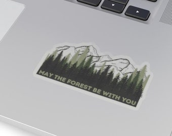 May include: A sticker with a green forest and mountains in the background. The text "May the forest be with you" is printed below the image.