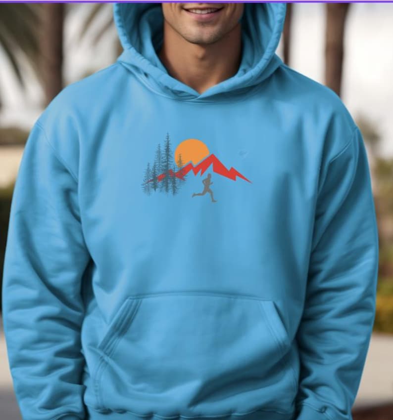 May include: A light blue hoodie with a graphic of a person running in front of a mountain range with a sun and trees.
