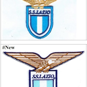 Peut inclure: Deux versions du logo de l'équipe de football de la Lazio. La version la plus ancienne présente un aigle doré avec un bouclier bleu et blanc affichant le texte "S.S. LAZIO". La version la plus récente présente un aigle doré avec un bouclier bleu et blanc affichant le texte "S.S. LAZIO" et un symbole de marque déposée.