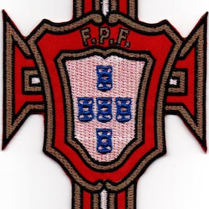 Puede incluir: Un parche bordado rojo y marrón con un escudo en el centro. El escudo tiene un fondo blanco con cinco estrellas azules de cinco puntas. El texto "F.P.F." está por encima del escudo.