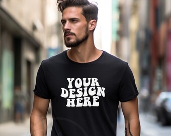 May include: A black t-shirt with the text "YOUR DESIGN HERE" in white letters. The shirt is being worn by a person with a beard and a tattoo on their arm.