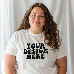 May include: A white t-shirt with the text "YOUR DESIGN HERE" in black retro-style lettering.