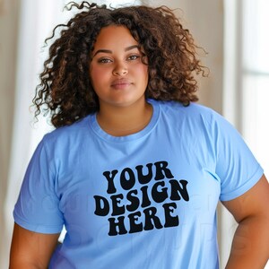 May include: A light blue t-shirt with the text "YOUR DESIGN HERE" in a retro font.
