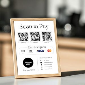 May include: A white sign with a wooden frame displays a Scan to Pay section with QR codes for PayPal, Venmo, and Cash App. The sign also includes a section for Also Accepted, which shows a VISA logo and a credit card symbol. The sign also includes a business logo, business name, and contact information.