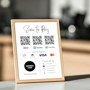 May include: A white sign with a wooden frame, displaying a scan to pay option with QR codes for Zelle, Venmo, and Cash App. The sign also indicates that VISA is accepted and includes a business logo and contact information.