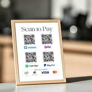 May include: A framed sign with the text "Scan to Pay" and QR codes for Venmo, Zelle, Cash App, and PayPal. The sign also indicates that cash, credit cards, Visa, and Mastercard are accepted. The frame is a light wood color.