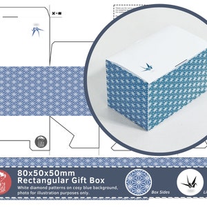 以下が含まれることがあります： 青い背景に白いダイヤモンド模様が施された長方形のギフトボックス。サイズは8x5x5cm。蓋には鶴のモチーフ。Tiny Fugu Shopのボックスです。