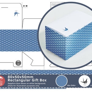 Puede incluir: Una caja de regalo azul y blanca con un patrón de olas. La caja mide 80 mm x 50 mm x 50 mm y tiene una tapa con un motivo de grúa de papel. La caja es para empaquetar pequeños regalos.