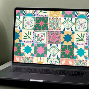 May include: A laptop computer with a colourful tiled pattern displayed on the screen. The tiles are in shades of pink, green, blue, yellow, and white. The laptop is sitting on a light green surface.