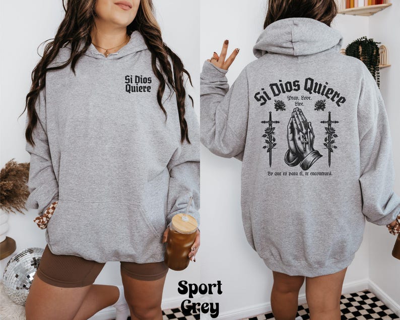 May include: A gray hooded sweatshirt with the text "Si Dios Quiere" and a graphic of praying hands with crosses. The text below the graphic reads "Pray, Love, Live.  Se que es para ti, si te encuentras."