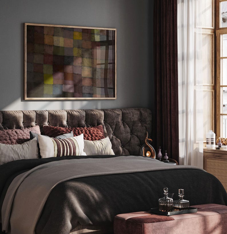May include: A bedroom scene featuring a tufted headboard, a bed with a black comforter and a gray blanket, and decorative pillows. A framed abstract painting hangs above the bed. The room is decorated with dark red curtains and a small ottoman.
