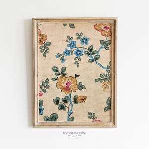 May include: A framed print of a vintage floral wallpaper design. The wallpaper features a repeating pattern of blue, yellow, and pink flowers on a cream background.