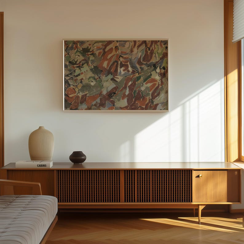 May include: A mid-century modern living room featuring a wooden credenza with a slatted front and a solid door. Above the credenza hangs an abstract painting in a silver frame. Decorative vases and a book are on top of the credenza.