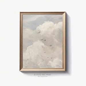 Könnte beinhalten: Ein gerahmtes Gemälde eines bewölkten Himmels mit einer Vogelschar, die in Formation fliegt. Der Himmel ist in einem sanften, gedämpften Blau gehalten und die Wolken sind weiß und flauschig. Das Gemälde ist in einem einfachen, goldenen Rahmen.