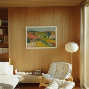 以下が含まれることがあります： 明るい木製の壁に額装された風景画が飾られたインテリア。白い椅子とソファ、そして紙製のランタンランプが見えます。絵画は、カラフルな田園風景を描いています。