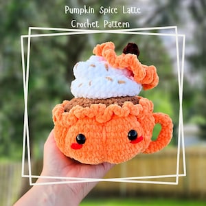 May include: A crocheted pumpkin spice latte with a white whipped cream topping and a brown sprinkle. The latte is in a crocheted orange mug with a brown handle and cute black eyes. The text "Pumpkin Spice Latte Crochet Pattern" is above the latte.