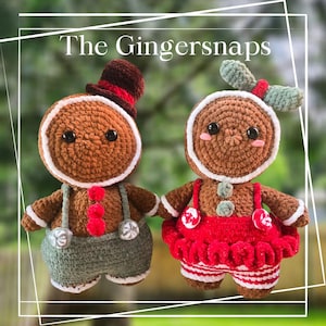 May include: Two crocheted gingerbread people, one wearing a green and brown outfit with a red bow tie and a brown hat, the other wearing a red and white dress with a green bow. The text "The Gingersnaps" is written above the figures.