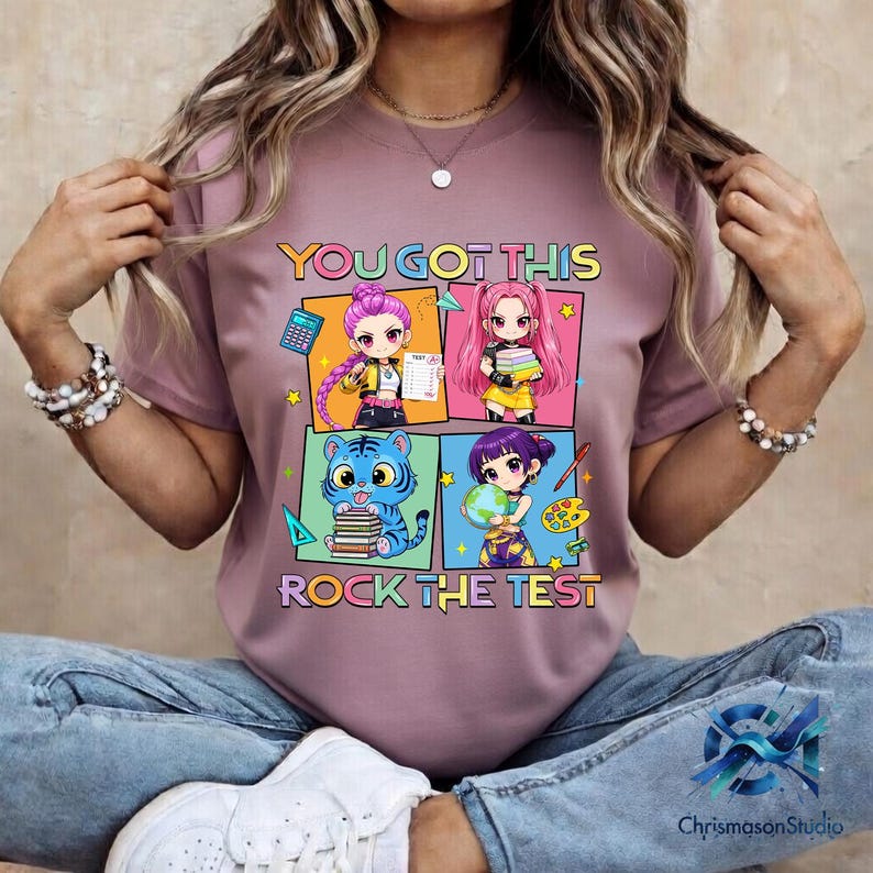 May include: Mauve t-shirt with a colorful graphic that says "YOU GOT THIS" and "ROCK THE TEST". The graphic features four anime-style characters with school-related items like books and a calculator.