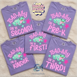 Könnte beinhalten: Eine Sammlung von lavendelfarbenen T-Shirts mit einem Frosch-Motiv und dem Text "TOAD-ALLY ON TO" gefolgt von "Second!", "Pre-K", "First!", "Kinder" und "Third!". Die Shirts haben ein digitales Design-Logo.