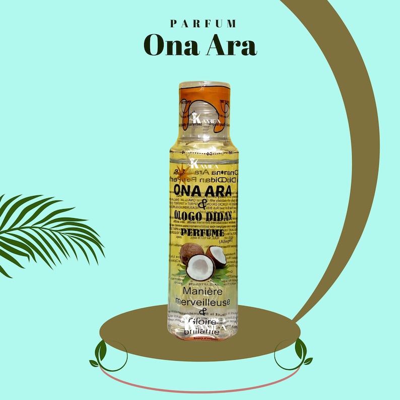May include: A clear glass bottle with a yellow cap and label. The label reads "Ona Ara & Ologo Didan Perfume". The bottle is filled with a yellow liquid and has a coconut design on the front. The bottle is sitting on a brown surface.