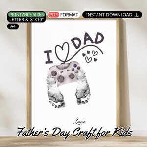 Könnte beinhalten: Druckbarer Vatertagsbastelbogen für Kinder. Das Design zeigt eine Handabdruck, der einen Videospielcontroller mit dem Text "I ♥ DAD" und "Love, Father's Day Craft for Kids" hält.
