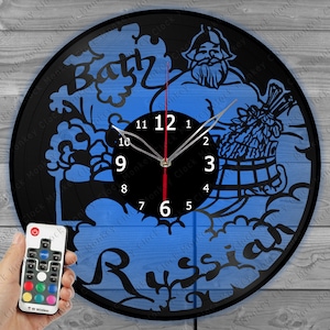 May include: A black vinyl record clock with a blue background featuring a cartoon illustration of a man in a bath with the text "Bath Russian" and a clock face with Roman numerals.