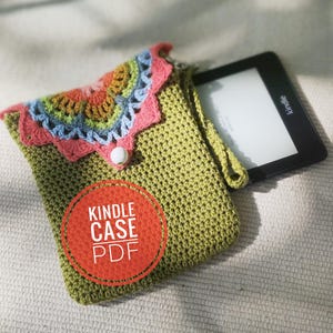 Może przedstawiać: Zielony, szydełkowy pokrowiec na Kindle z kolorowym, szydełkowym wzorem kwiatu na górnej klapie. Pokrowiec ma pasek i zapięcie na guzik. Tekst "Kindle Case PDF" jest nadrukowany na czerwonym kółku.