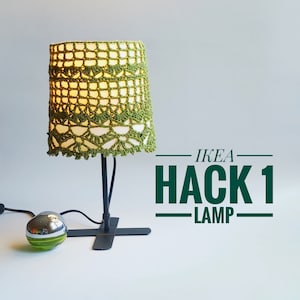May include: A black table lamp with a green crocheted lampshade. The lamp is labeled "IKEA HACK 1 LAMP".