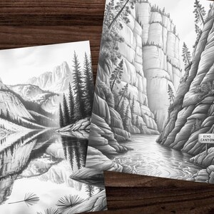 May include: Two black and white landscape art prints. One print depicts a mountain range reflected in a lake. The other print shows a canyon with a river and a sign that reads "Echo Canyon".