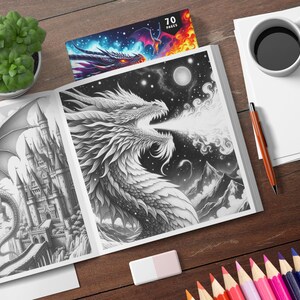 May include: A black and white coloring book with a dragon breathing fire on the cover. The book has 70 pages and is open to a page with a dragon flying over a castle.