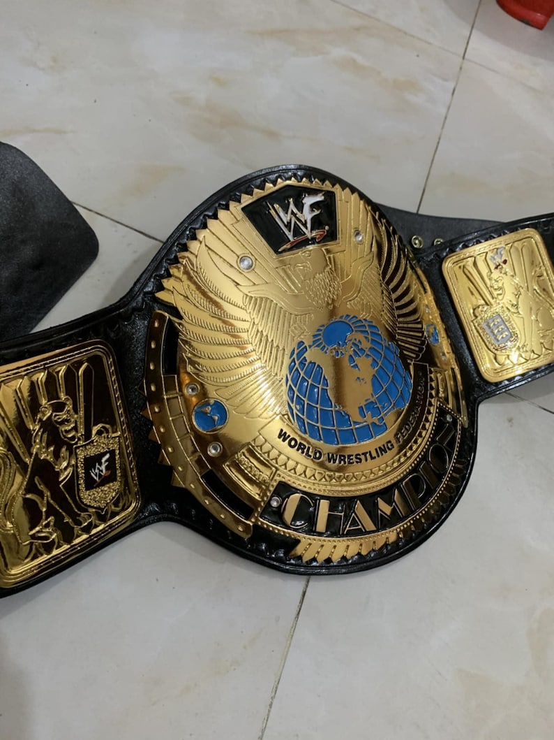 May include: A gold and black wrestling championship belt with a blue globe and the words "World Wrestling Federation Champion" on the front.