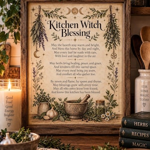 May include: A framed wall art print titled Kitchen Witch Blessing featuring a poem, botanical illustrations of herbs, a mortar and pestle, and moon phases. The design is printed on aged parchment paper with a dark brown wooden frame.