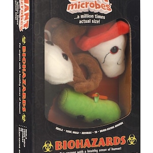 May include: A black cardboard box containing three plush toys from the Giant Microbes collection. The box features the text Giant Microbes, Biohazards, and lists Ebola, Toxic Mold, Anthrax, TB, and Brain-Eating Amoeba as the included items.