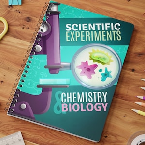 Op de afbeelding: Een spiraalgebonden notitieboek met een blauwgroene en paarse kaft met een illustratie van een microscoop, een petrischaal met micro-organismen en de tekst "SCIENTIFIC EXPERIMENTS & CHEMISTRY BIOLOGY" in witte en roze letters op de voorkant.