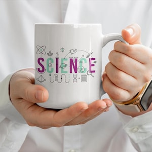 May include: A white ceramic mug featuring the word SCIENCE printed in large purple and teal letters. The design includes small black line art icons of scientific elements like an atom, a rocket, a DNA strand, a beaker, and a magnifying glass.
