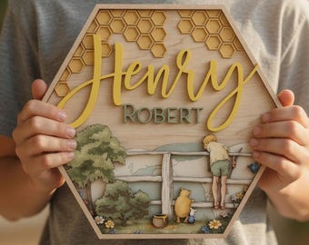 May include: A hexagonal wooden wall sign featuring a layered design with a honeycomb pattern at the top. The name Henry is written in large yellow script, with Robert in green block letters below. A scene shows a child and a bear by a fence.