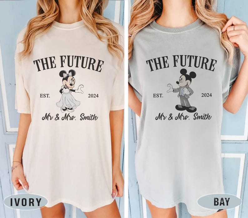 Puede incluir: Dos camisetas, una de color marfil y la otra azul claro, con un gr&aacute;fico de Mickey y Minnie Mouse vestidos con atuendos de boda. El texto en las camisetas dice "The Future Est. 2024 Mr & Mrs. Smith".