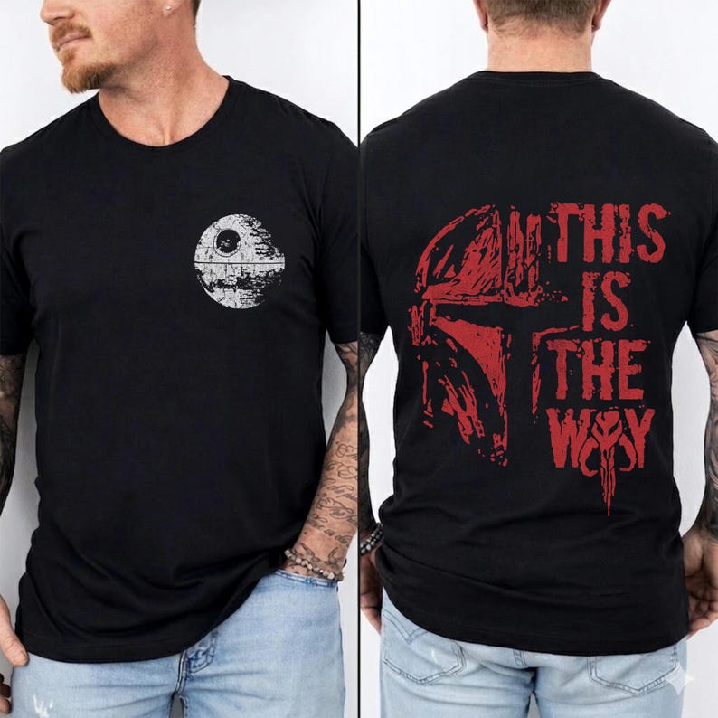 May include: Black t-shirt featuring a white Death Star graphic on the front and a red Mandalorian helmet design with the text "THIS IS THE WAY" on the back. The shirt is a crew neck style.