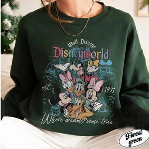 May include: Forest green sweatshirt featuring a colorful graphic of Disney characters, including Mickey Mouse, Minnie Mouse, Donald Duck, and Goofy. The design includes the text "Walt Disney's Disneyworld" and "Where dreams come true", with the year "1971".