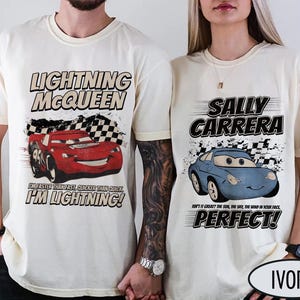 May include: Ivory-colored t-shirts featuring Lightning McQueen and Sally Carrera from the Cars movie. The Lightning McQueen shirt has the text "I'M LIGHTNING!" and the Sally Carrera shirt says "PERFECT!"