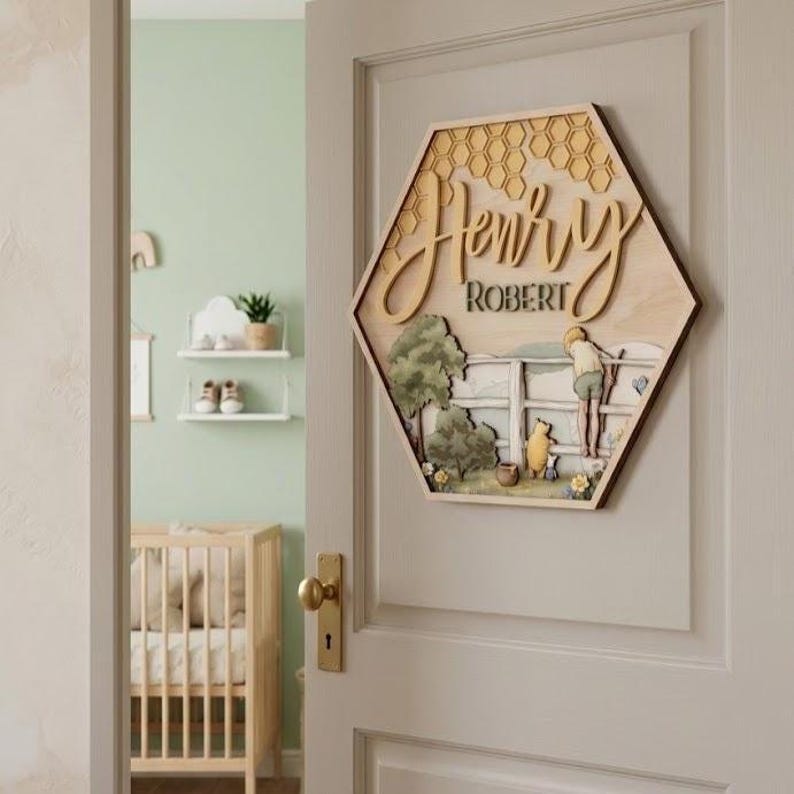 May include: A hexagonal wooden wall sign featuring a honeycomb pattern at the top, the name Henry Robert in raised script and block lettering, and a layered illustration of a child and a bear standing by a fence in a grassy landscape.