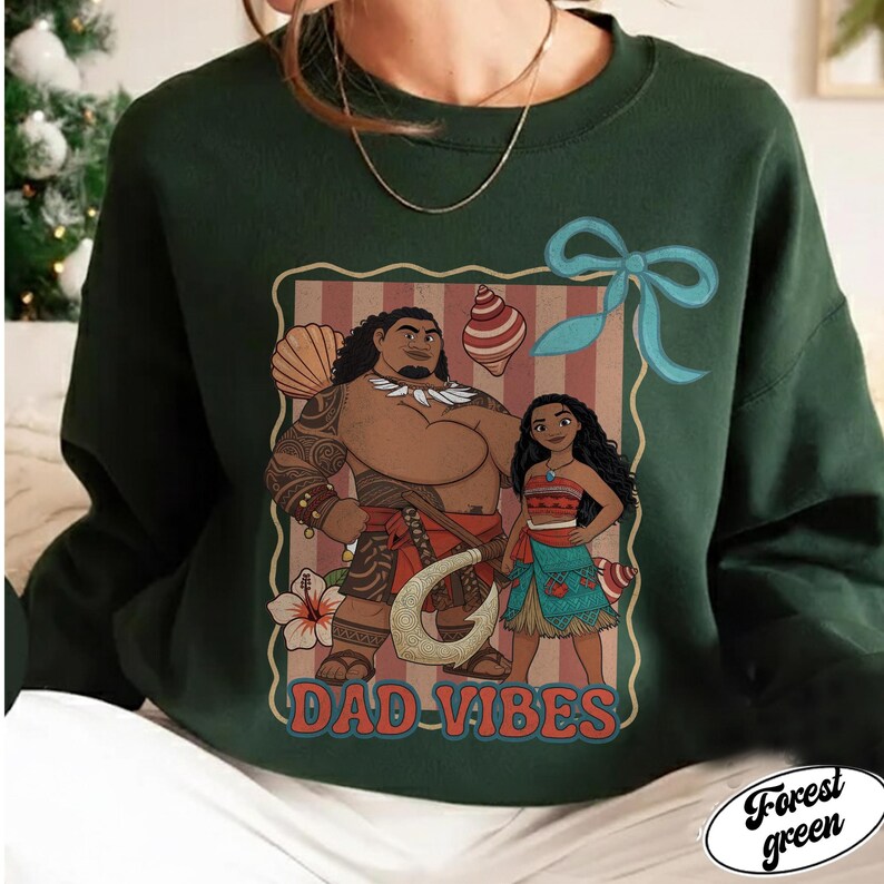 May include: Forest green sweatshirt featuring a graphic of two cartoon characters with the text "DAD VIBES". The graphic is framed with a light brown border and includes a blue bow and tropical elements.